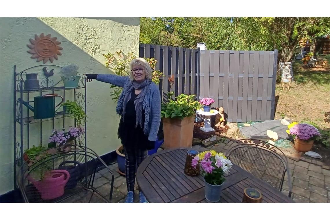 Ute Mayer auf der Terrasse ihrer Doppelhaushälfte in Grafenberg: Hinter dieser Wand befinden sich die maroden Abwasserrohre.