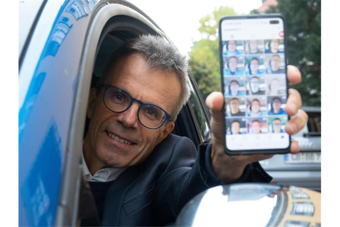 Uwe Baltner sitzt in seinem Auto und zeigt auf seinem Handy sein Instagram-Profil. Foto: Gregor Bauernfeind/dpa