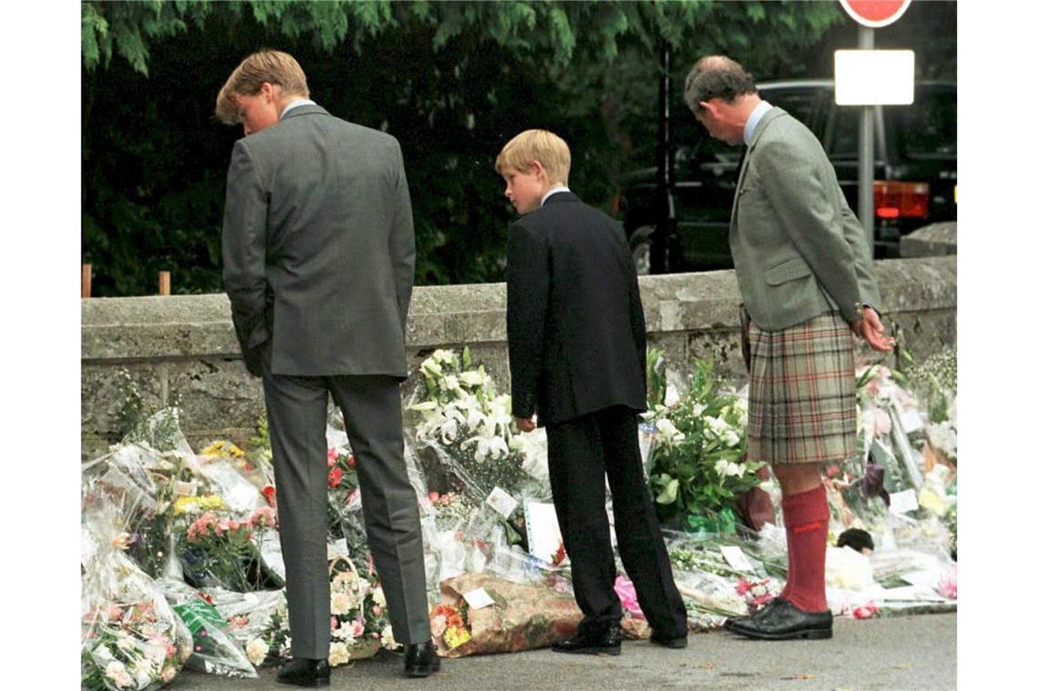 (v. l. n. r.) Prinz William, Prinz Harry und ihr Vater, der Prinz von Wales, halten vor den Toren von Balmoral Castle an, um sich die dort niedergelegten Blumengaben anzusehen.