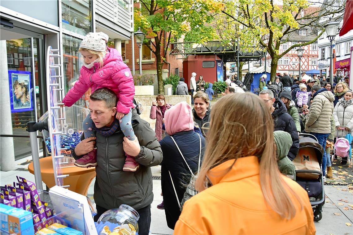 Velia (3 Jahre alt) dreht auf den Schultern von Papa am Glücksrad. Dahinter bild...