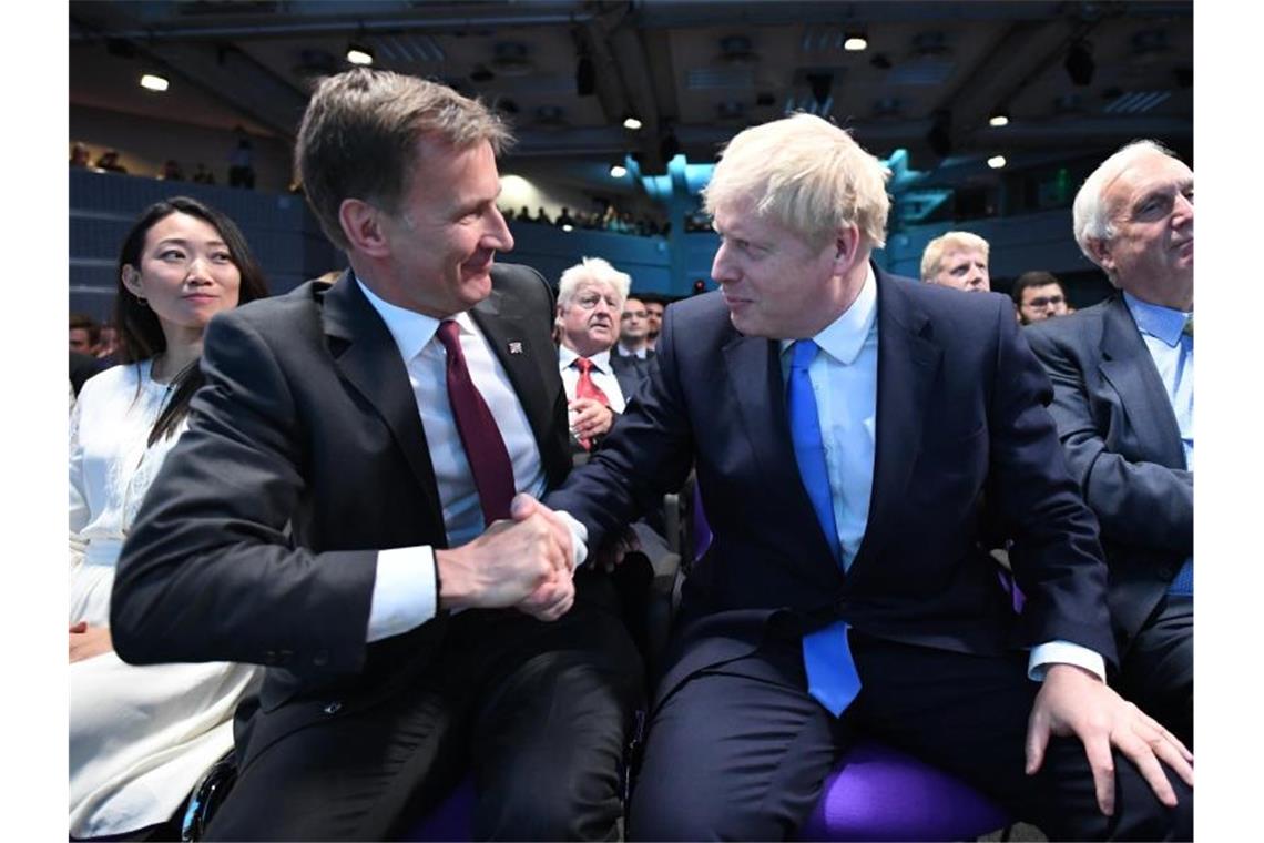 Boris Johnson neuer britischer Premierminister Verlierer und Gewinner: Der britische Außenminister Jeremy Hunt gratuliert Boris Johnson, nachdem das Ergebnis der Abstimmung unter den Tory-Mitgliedern verkündet wurde. Foto: Stefan Rousseau/PA Wire