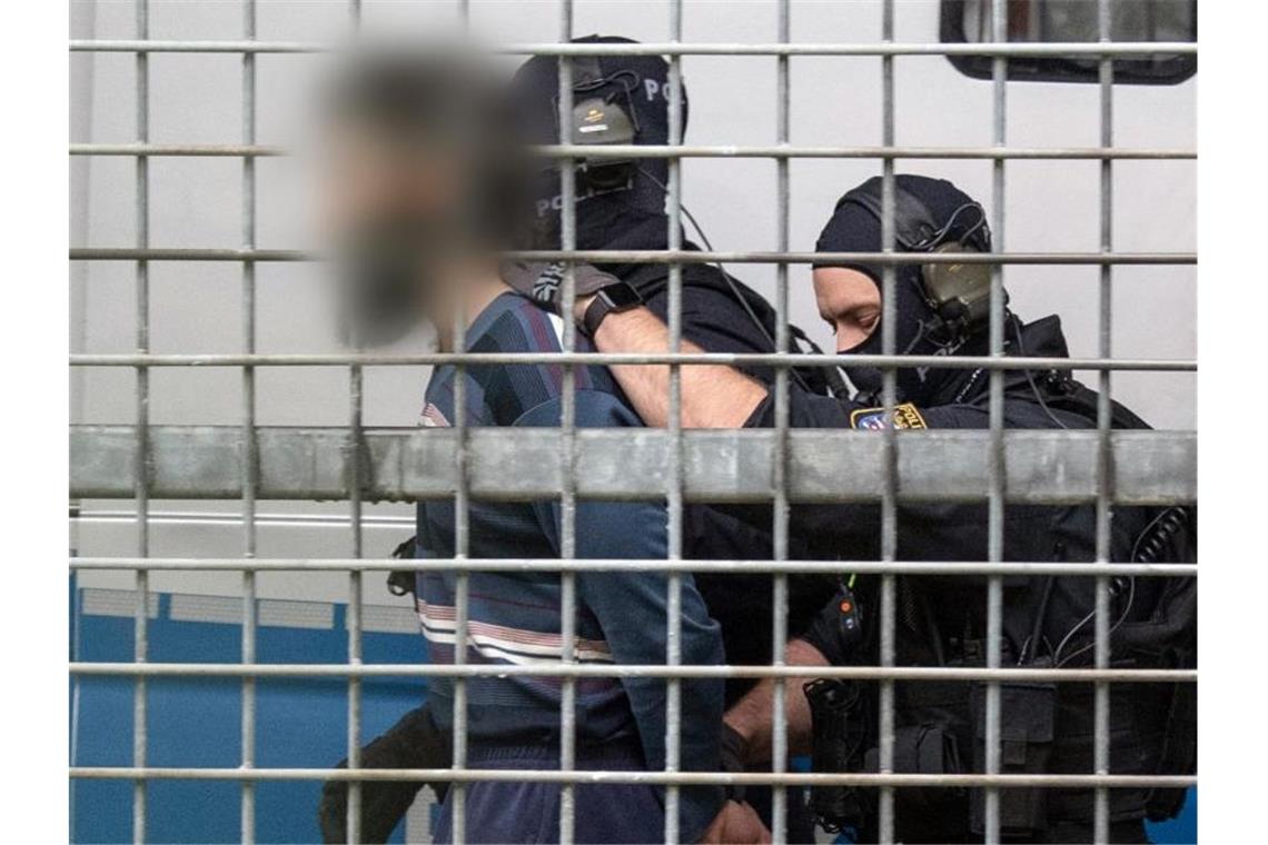Vermummte Beamte einer Spezialeinheit der Polizei bringen den terrorverdächtigen Mann zur Haftvorführung am Gericht. Foto: Boris Roessler/dpa