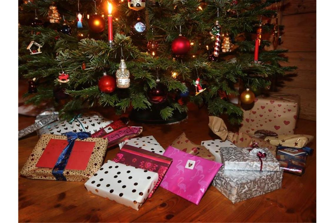 Verbraucher befürchten teurere Weihnachtsgeschenken Verpackte Weihnachtsgeschenke liegen in einem Wohnzimmer unter einem geschmückten Weihnachtsbaum. Foto: Karl-Josef Hildenbrand/dpa
