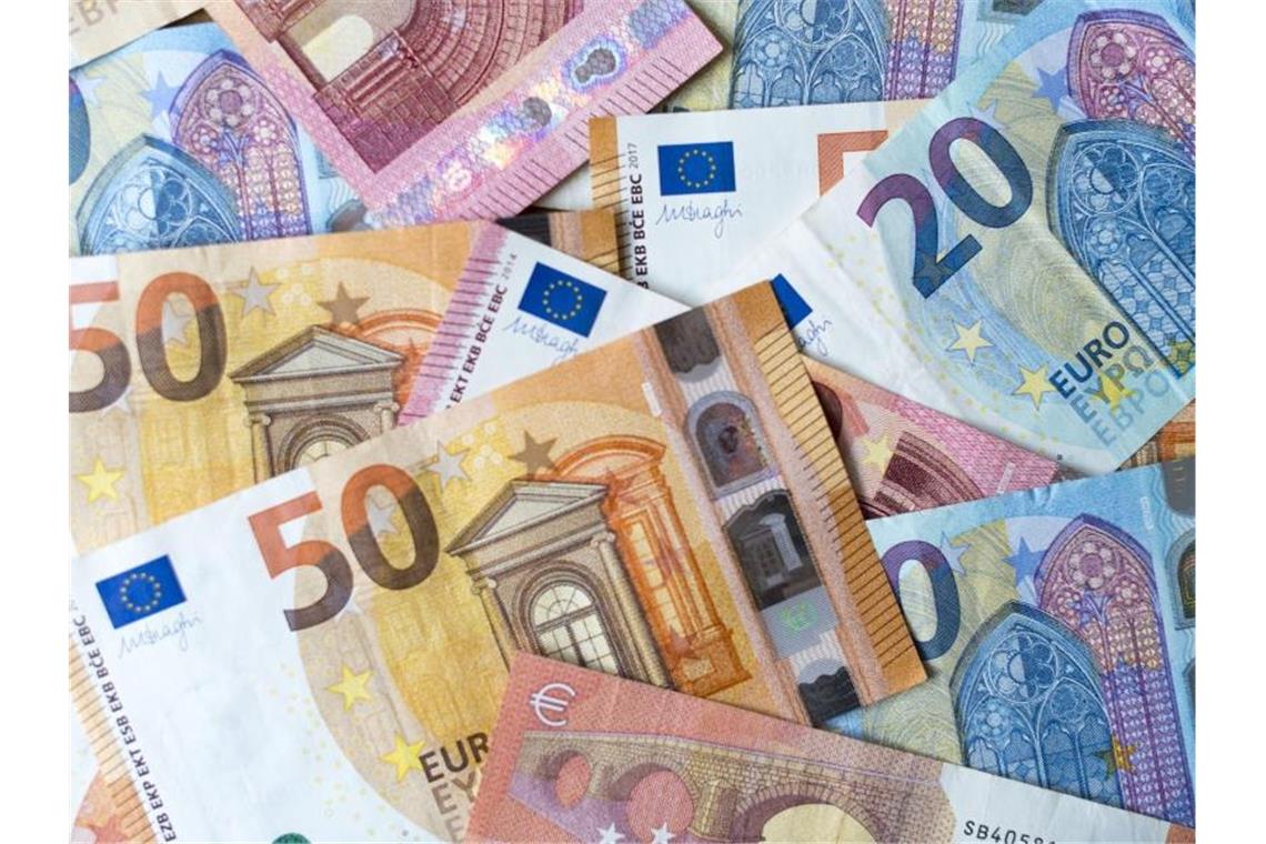 Verschiedene Banknoten liegen auf einem Haufen. Foto: Monika Skolimowska/zb/dpa/Archivbild