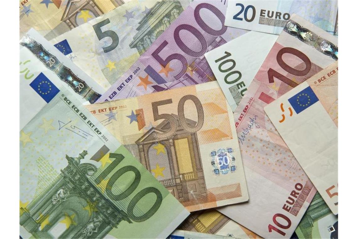 Land verdoppelt Mittel für kommunale Infrastruktur Verschiedene Euro-Banknoten liegen übereinander. Foto: Daniel Reinhardt/Archivbild
