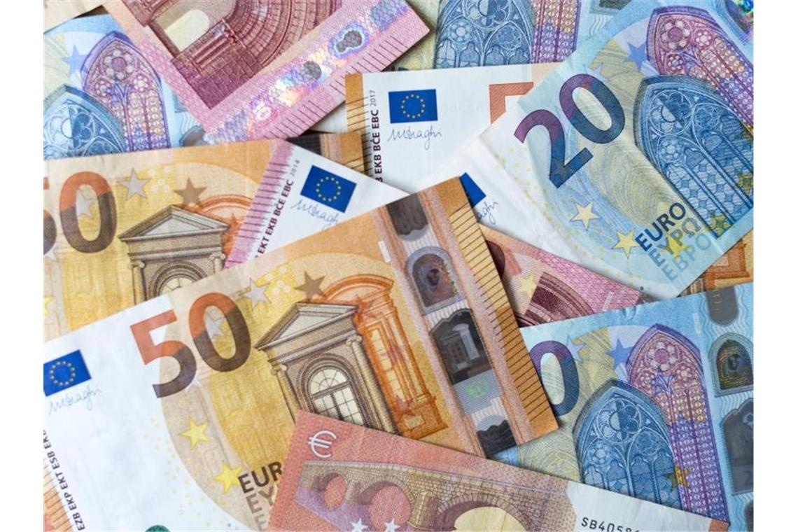 Land erwartet zwei Milliarden Euro zusätzlich Verschiedene Geldscheine liegen auf einem Tisch. Foto: Monika Skolimowska/zb/dpa/Archivbild