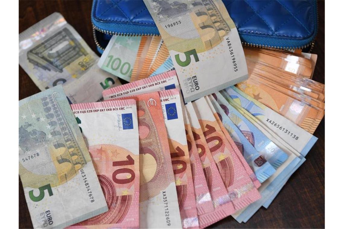 Lottospieler gewinnt fast 2,4 Millionen Euro im Spiel 77 Verschiedene Geldscheine liegen auf einem Tisch. Foto: Robert Michael/zb/dpa