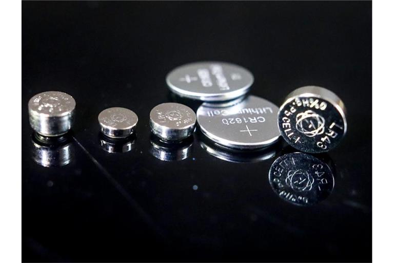 Verschiedene Minibatterien (Knopfzellen) liegen auf einer Glasplatte. Foto: Christoph Schmidt/dpa
