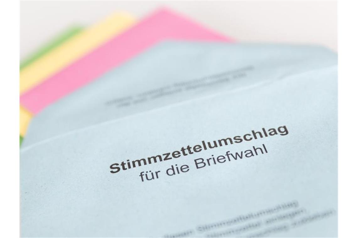 Verschiedene Stimmzettel stecken in einem Stimmzettelumschlag für die Briefwahl. Foto: Friso Gentsch/dpa