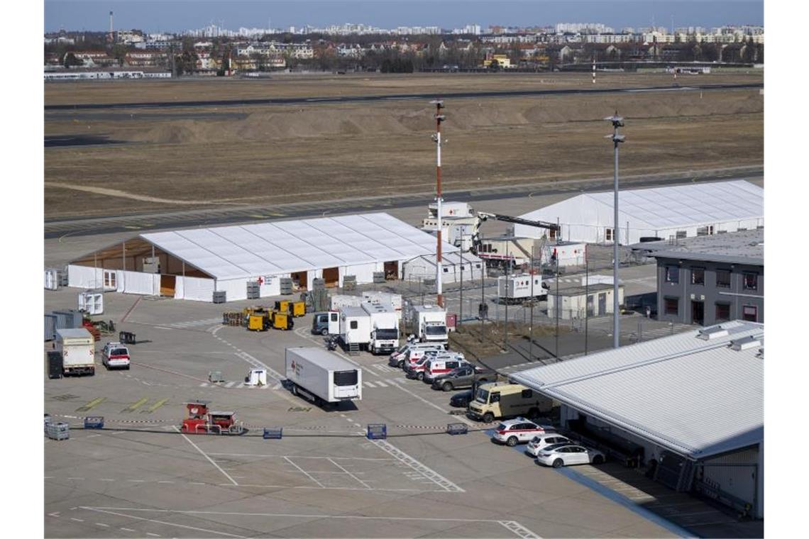 Betten und Kinderbilder - neues Leben auf Flughafen Tegel Versorgungszelte stehen auf dem Rollfeld des ehemaligen Flughafens Berlin-Tegel. Foto: Monika Skolimowska/dpa-Zentralbild/dpa