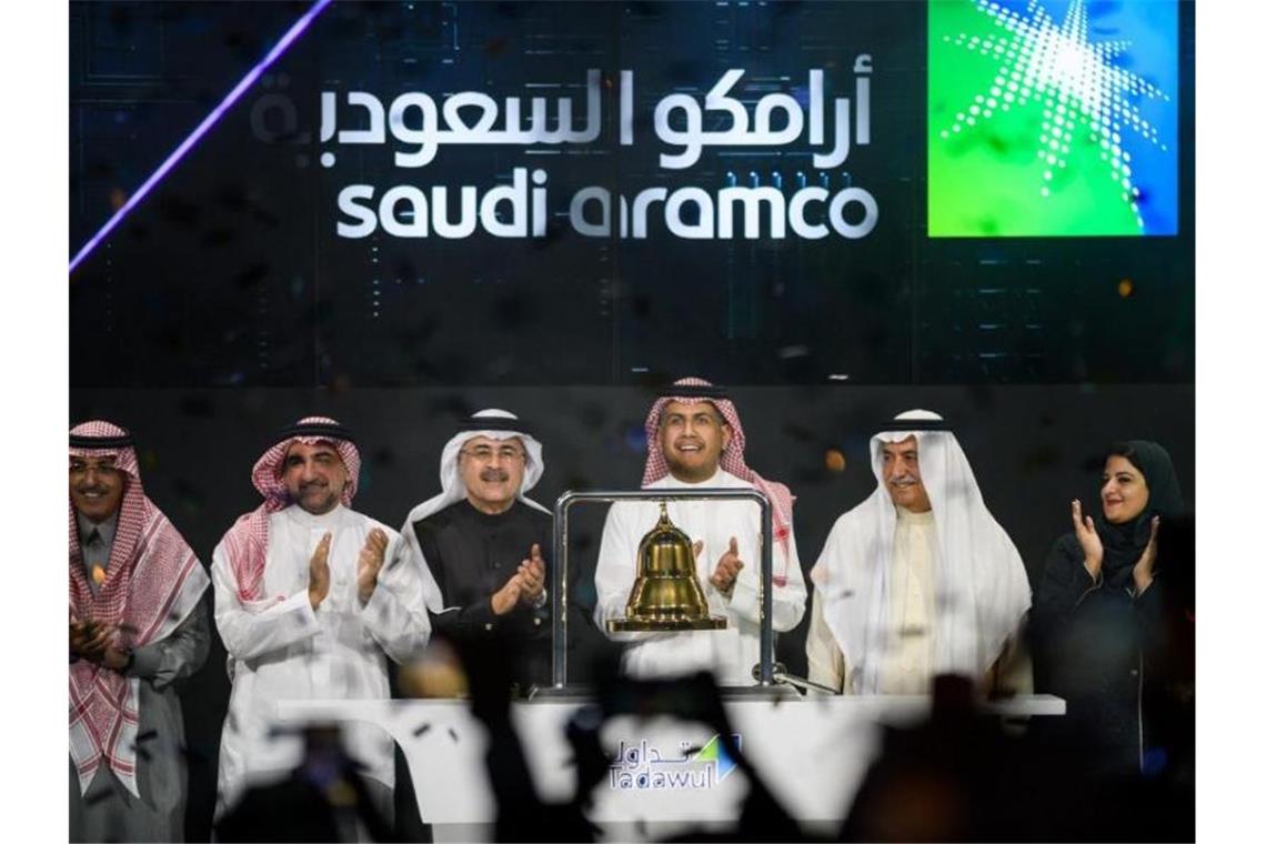 Vertreter der staatlichen saudi-arabischen Ölgesellschaft Aramco und Börsenvertreter feiern den Aramco-Börsengang. Foto: -/Saudi Press Agency/dpa