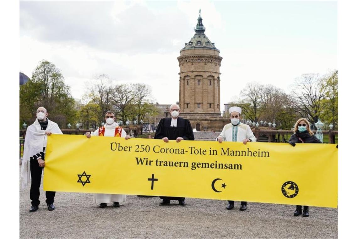 Religionsgemeinschaften gedenken gemeinsam der Corona-Toten Vertreter und Vertreterinnen der Religionsgemeinschaften mit einem Transparent. Foto: Uwe Anspach/dpa