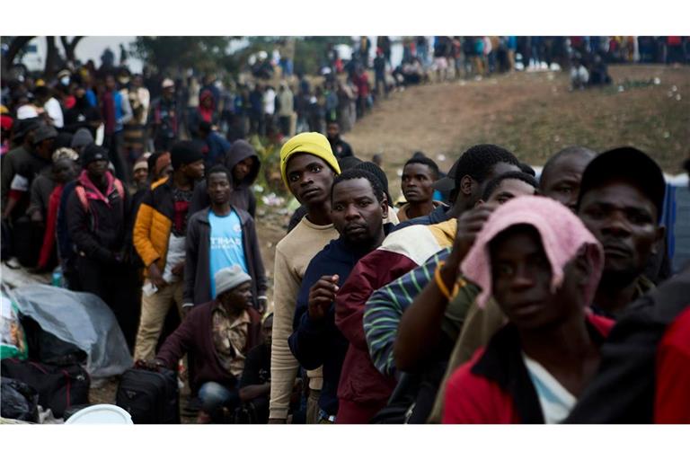 Vertriebene Migranten stehen in Durban in Südafrika vor einer Abschiebeeinrichtung Schlange.