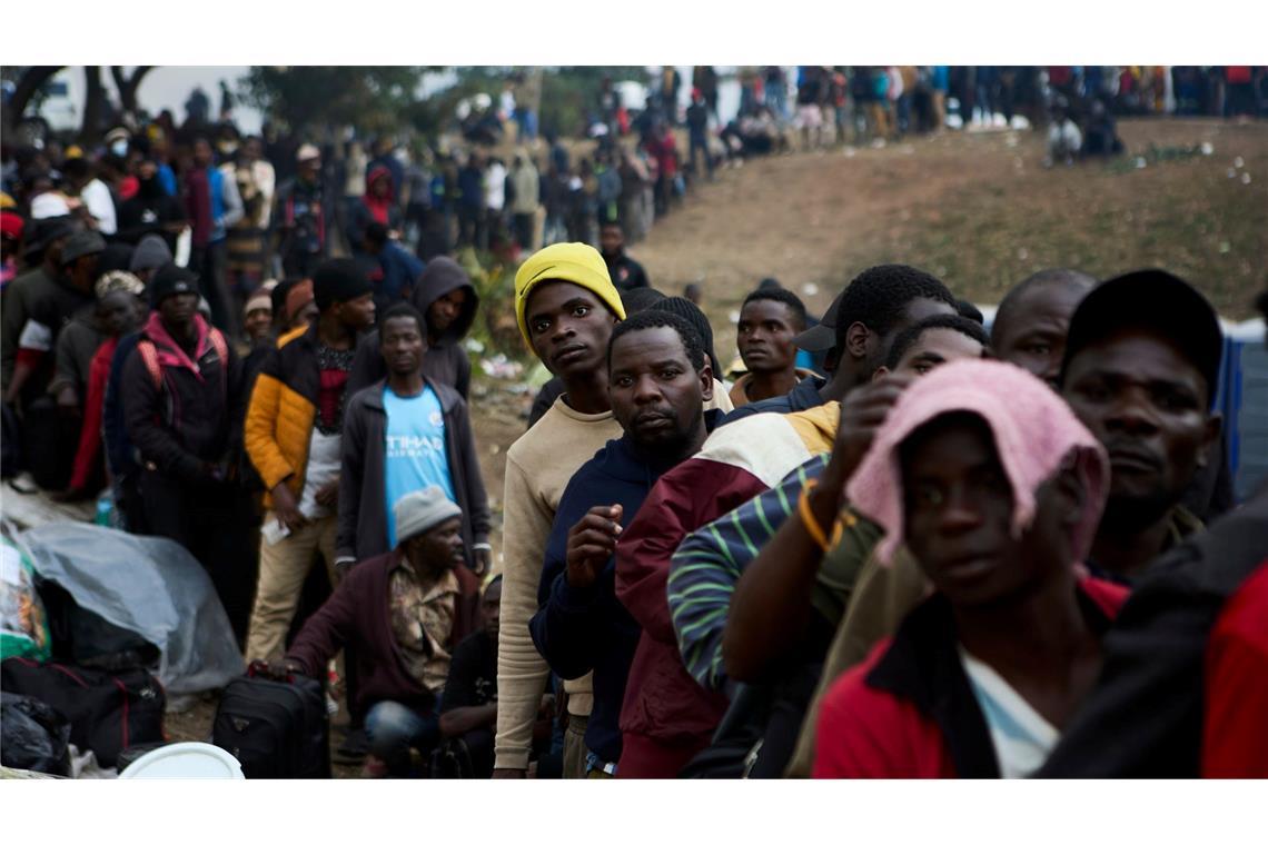 Vertriebene Migranten stehen in Durban in Südafrika vor einer Abschiebeeinrichtung Schlange.