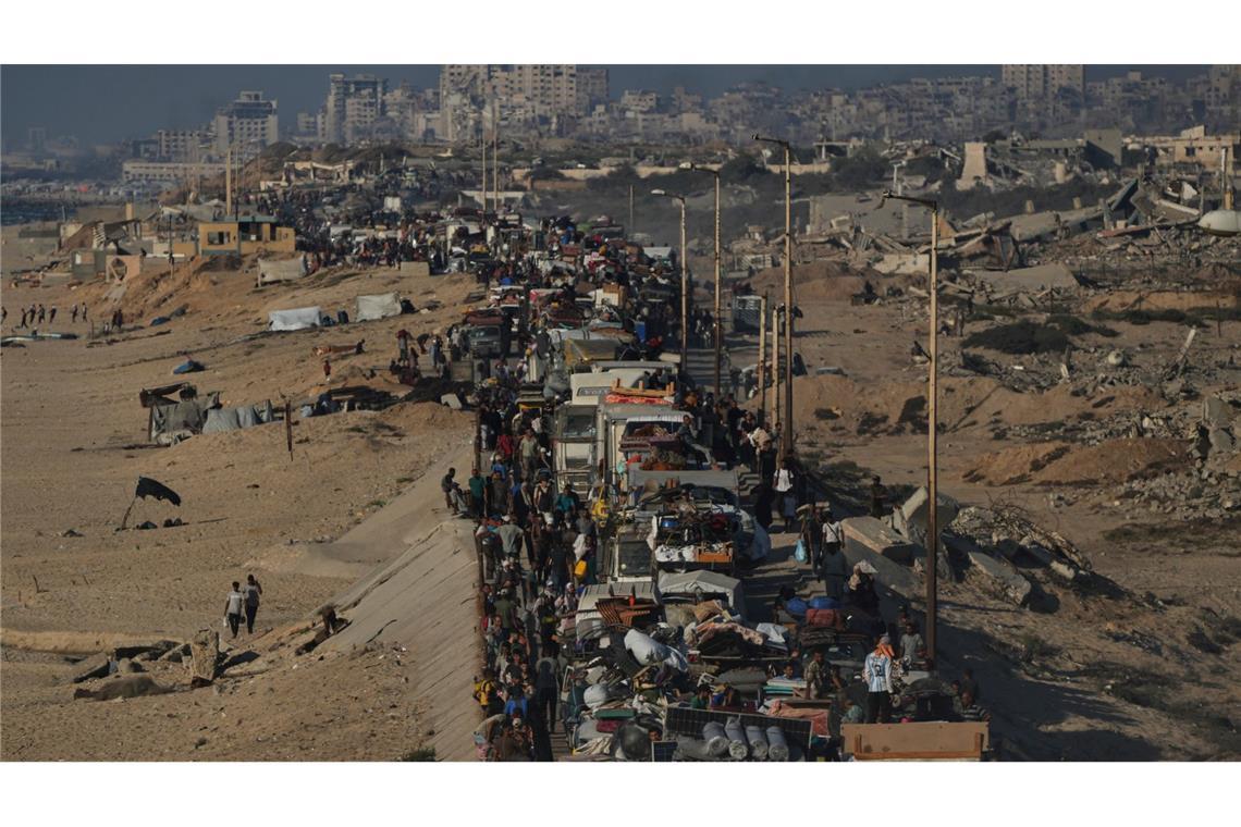 Vertriebene Palästinenser fliehen zu Fuß und in Fahrzeugen aus dem nördlichen Gazastreifen und tragen ihre Habseligkeiten entlang der Küstenstraße in Richtung des südlichen Gazastreifens.
