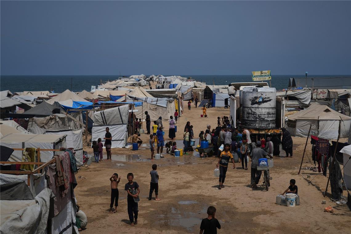 Vertriebene Palästinenser sammeln während einer Hitzewelle in einem behelfsmäßigen Zeltlager in Chan Junis im Gazastreifen Wasser aus einem Lastwagen. (Archivbild)