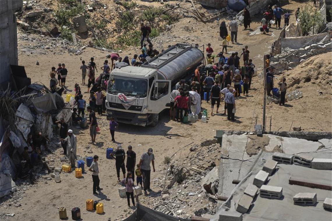 Vertriebene Palästinenser versammeln sich in der Stadt Gaza, um Wasser aus einem Lastwagen zu holen. (Archivbild)