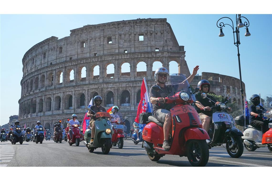 Vespa-Fans fahren am Kolosseum vorbei.