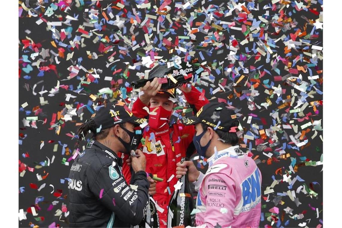 Vettel (M) und der Zweitplatzierte Sergio Perez feiern den neuen und alten WM-Champion Hamilton. Foto: Murad Sezer/POOL Reuters/AP/dpa