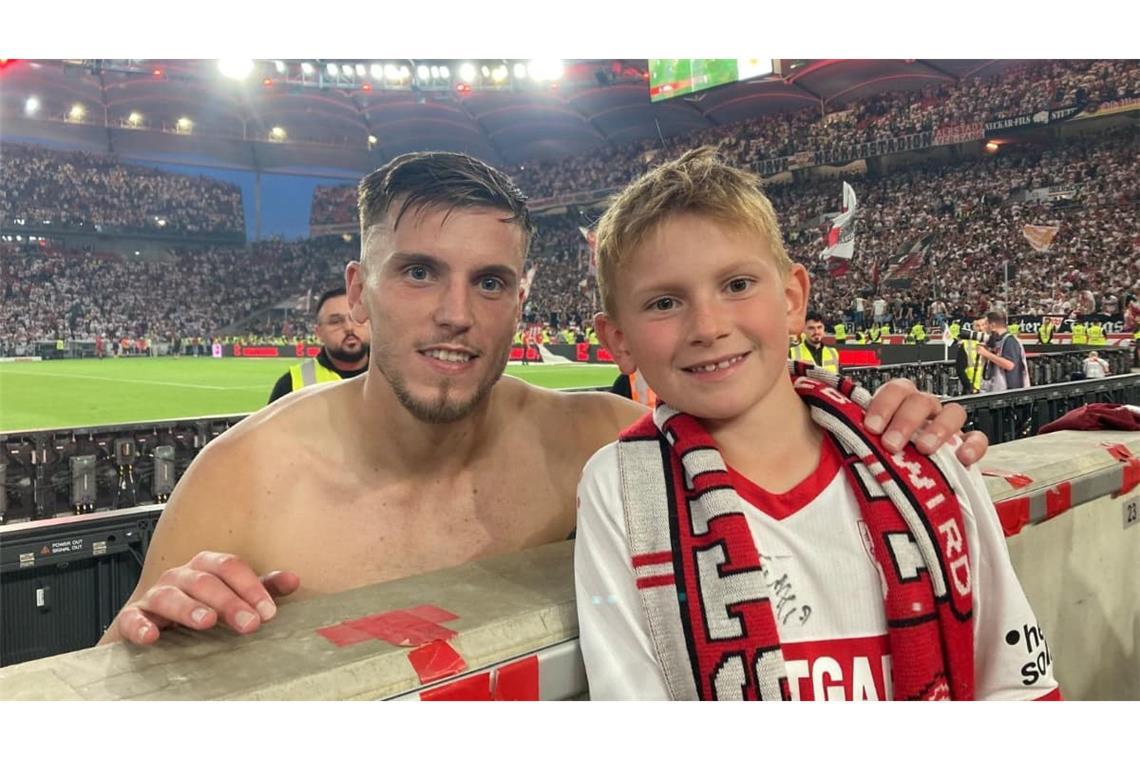 VfB-Fan-Dominik Heumesser mit dem bosnischen Nationalspieler Ermedin Demirovic nach seinem im Fernsehen auch gezeigten Plakat „Tausche Papa gegen VfB-Trikot.“