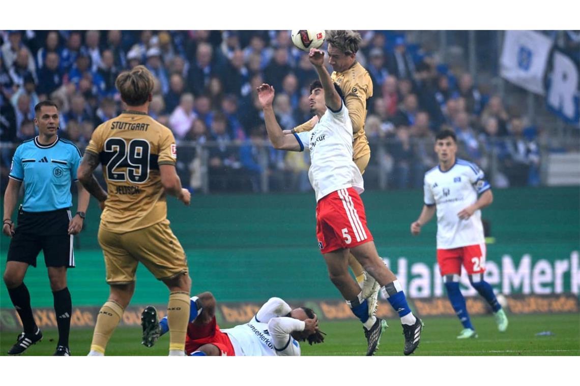 VfB-Mittelfeldspieler Angelo Stiller steigt im Luftduell zum Kopfball, während HSV-Spieler Martin Adeline versucht, den Ball abzufangen.