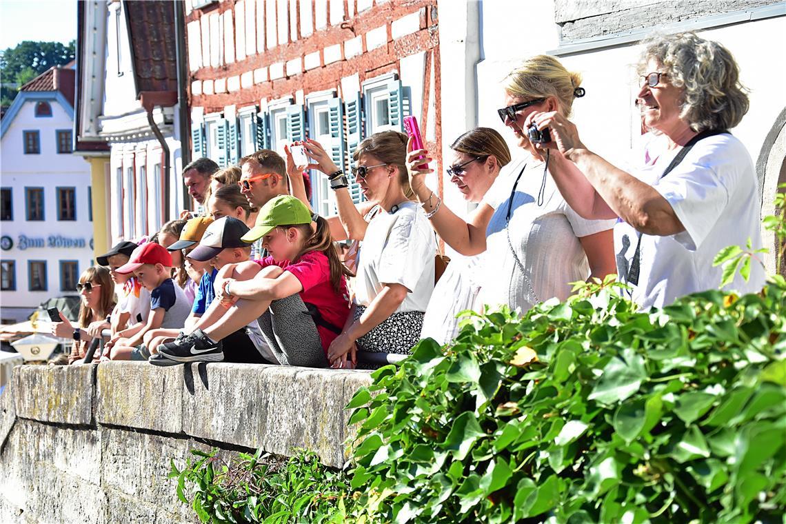 Viele Eltern und Großeltern am Marktplatz halten die Darbietungen der Kinder auf...