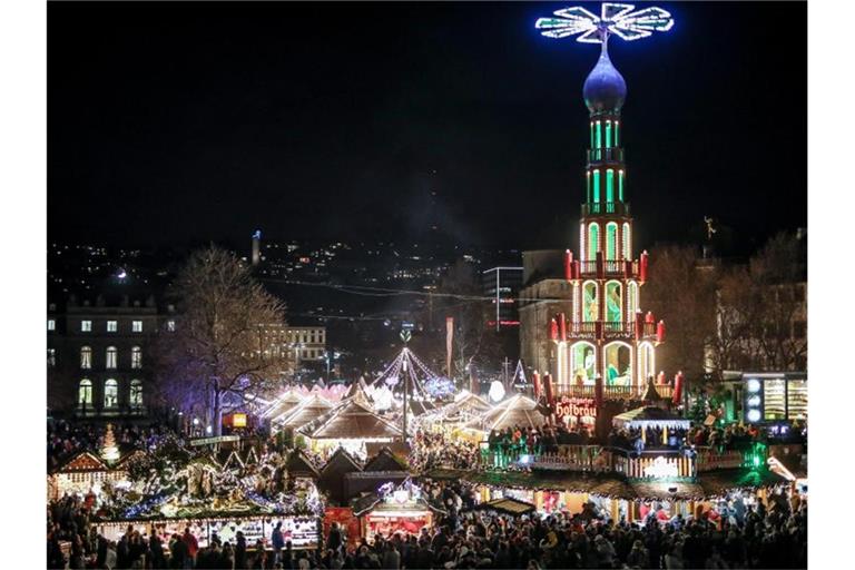 Viele Menschen sind auf dem Weihnachtsmarkt an der großen Pyramide auf dem Schlossplatz unterwegs. Foto: Christoph Schmidt/dpa