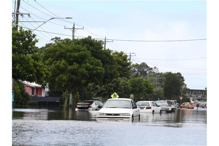 Viele Menschen versuchen vor den schnell steigenden Wassermassen zu fliehen. Foto: Jason O’brien/AAP/dpa