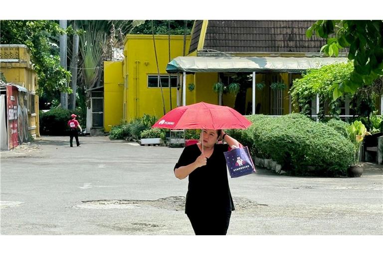 Viele schützen sich mit Schirmen vor der Sonne.