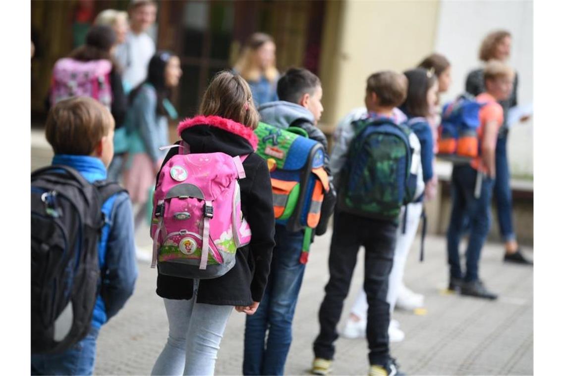 Viertklässler stehen mit Abstand zueinander auf dem Schulhof. Foto: Arne Dedert/dpa/Archivbild