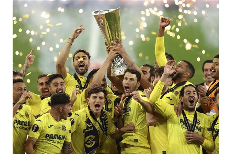 Villarreals Spieler heben den Pokal und feiern ihren Sieg. Foto: Maja Hitij/Pool Getty/AP/dpa