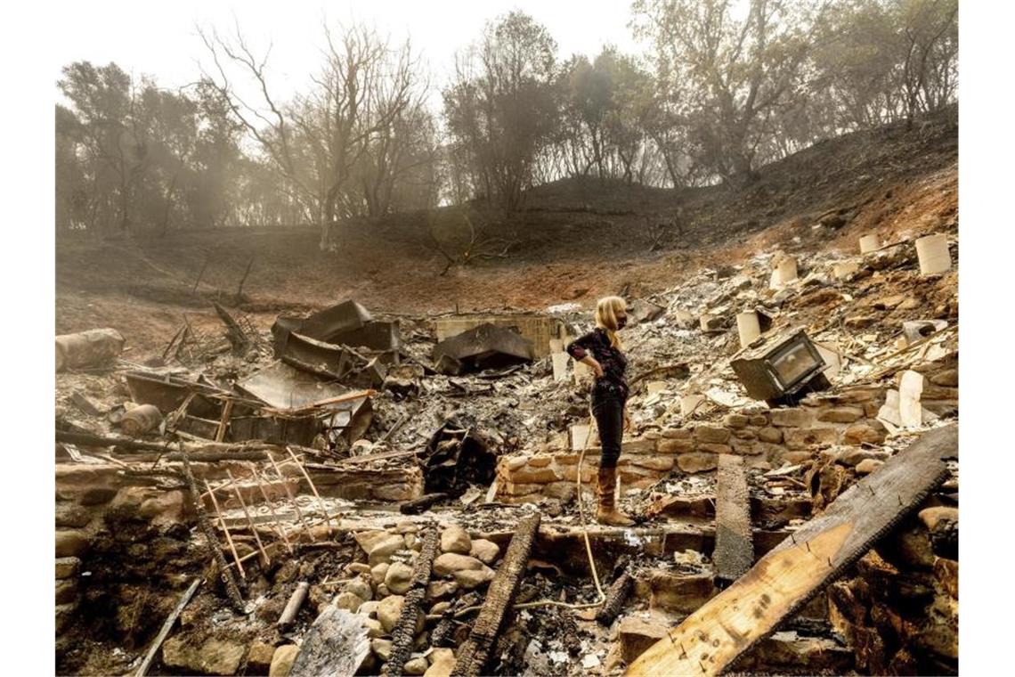 Brände in Kalifornien breiten sich weiter aus Völlige Zerstörung: Eine Frau inspiziert die Überreste des Hauses ihres Partners in Vacaville. Foto: Noah Berger/AP/dpa