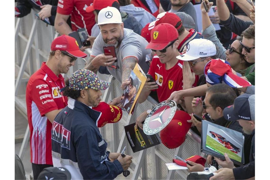 Volksnah: Sebastian Vettel (l) und Lewis Hamilton (2.v.l) erfüllen die Autogrammwünsche der kanadischen Radsportfans. Foto: Ryan Remiorz/The Canadian Press/AP