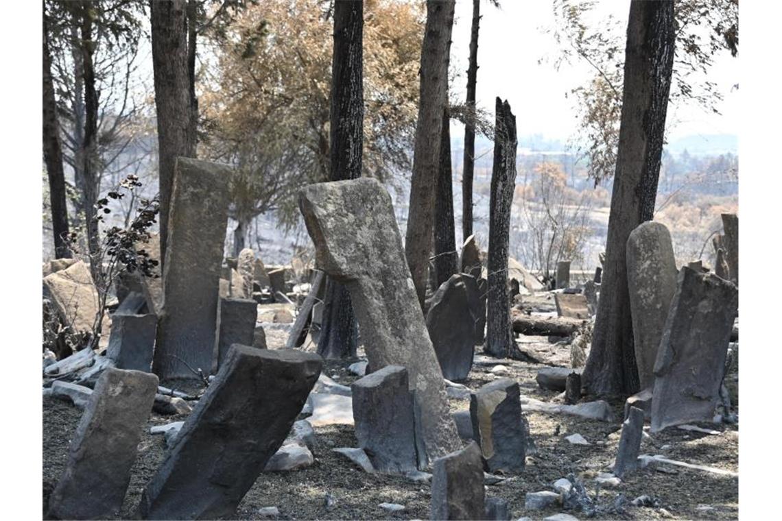 Vom Feuer zerstörte Grabsteine stehen auf dem Friedhof des Dorfes Kalemler (Antalya). Foto: Anne Pollmann/dpa