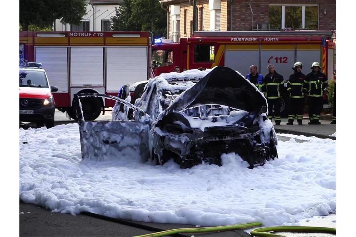 Vom Löschschaum bedeckt steht ein Auto nach einer Explosion auf der Straße im nordrhein-westfälischen Hürth. Foto: TNN/dpa
