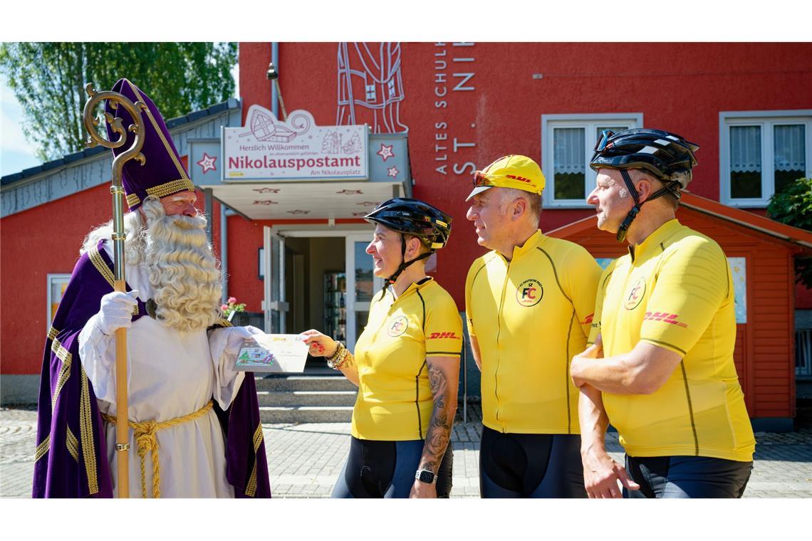 Postler radeln zum Weihnachtsmann nach Lappland Vom Nikolaus nehmen die Radfahrer beim Start ihrer langen Tour Post für den Weihnachtsmann in Lappland entgegen.
