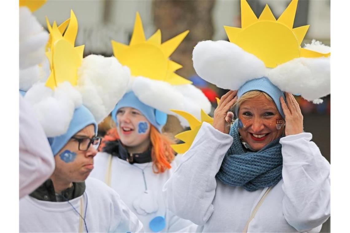 Vom Winde verweht: Karnevalisten in Köln. Foto: Oliver Berg/dpa