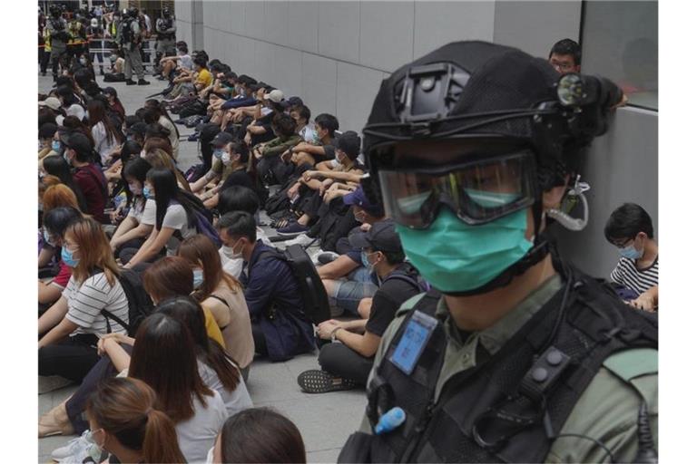 Von Bereitschaftspolizisten festgehaltene regierungskritische Demonstranten im Zentrum von Hongkong. Foto: Vincent Yu/AP/dpa