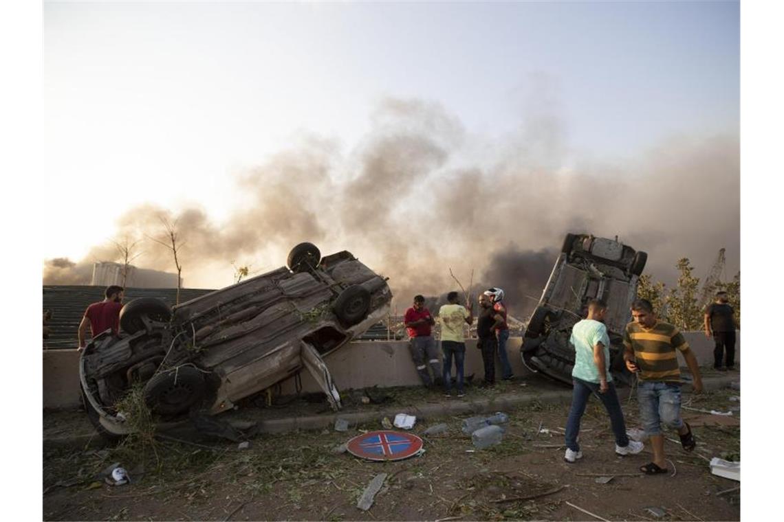 Von der Wucht der Explosion sind Autos umgekippt worden. Foto: Hassan Ammar/AP/dpa