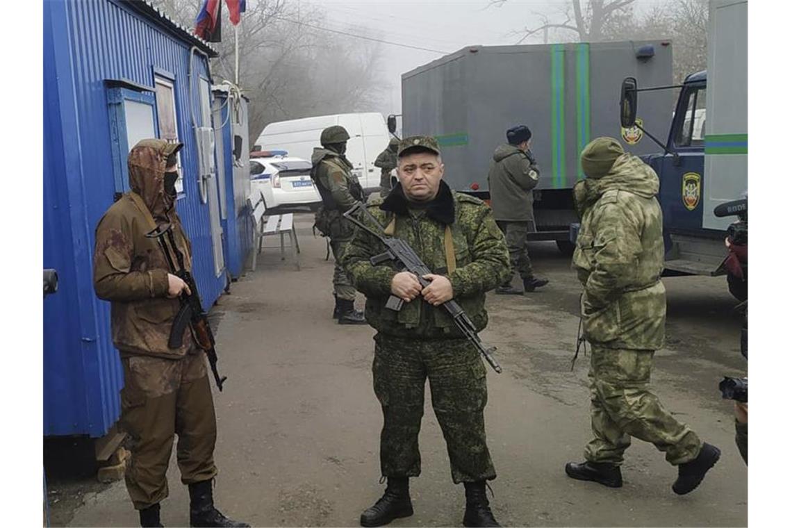 Ostukraine: Kiew und Separatisten tauschen Gefangene aus Von Russland unterstützte Separatistensoldaten bewachen in der Stadt Horliwka Fahrzeuge, in denen Ukrainer auf den Gefangenenaustausch warten. Foto: Alexei Alexandrov/AP/dpa