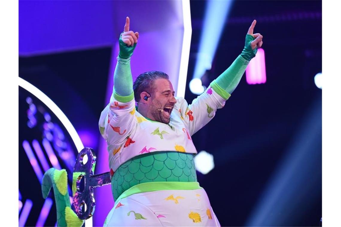 Von wegen ausgestorben: Sänger und Dino Sasha jubelt im Finale der ProSieben-Show „The Masked Singer“. Foto: Willi Weber/ProSieben/dpa