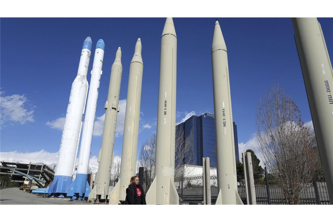 Welche Reichweite haben iranische Raketen? Vor Beginn der Feindseligkeiten mit Israel: Frau ohne Kopftuch vor Raketenausstellung im Iran (Archiv).
