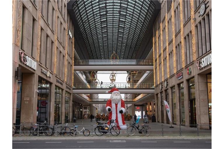 Vor dem Einkaufszentrum „Mall of Berlin“ steht eine Weihnachtsmann-Skulptur. Der Teil-Lockdown dämpft die Konsumlaune empfindlich. Foto: Christophe Gateau/dpa