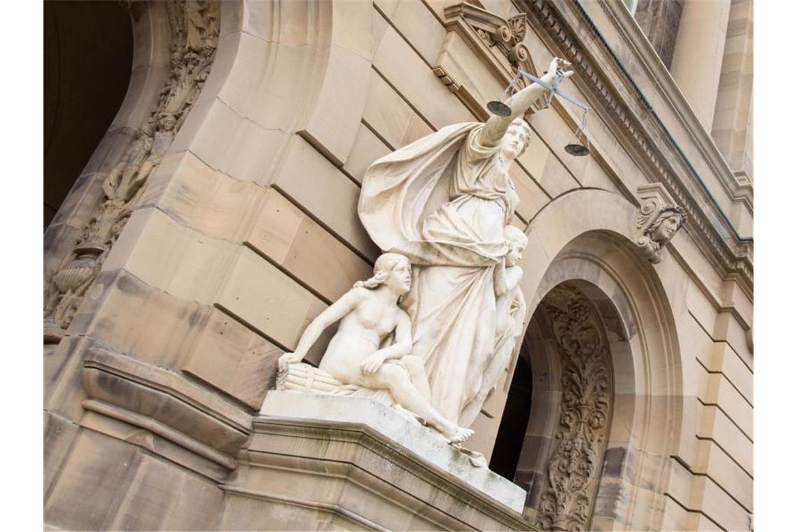 Vor dem Gerichtsgebäude hält eine Statue der Justitia eine Waagschale. Foto: Stefan Puchner/dpa/Archivbild