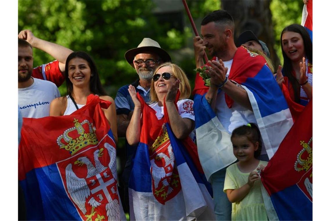 Einreise-Krimi um Djokovic - Gericht tagt am Montag Vor dem Hotel versammelten sich serbische Fans mit Nationalflaggen, um für Djokovic zu protestieren. Foto: James Ross/AAP/dpa