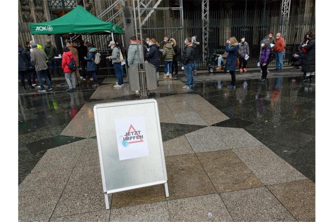 Vor dem Kölner Dom warten zahlreiche Menschen auf eine Impfung. Foto: Henning Kaiser/dpa