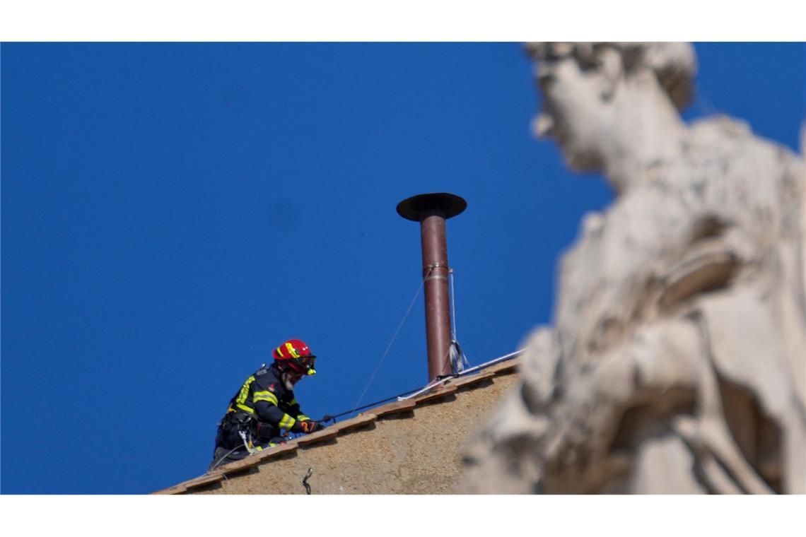 Bilder des Tages Vor dem Konklave: Ein Feuerwehrmann platziert den Schornstein auf dem Dach der Sixtinischen Kapelle.