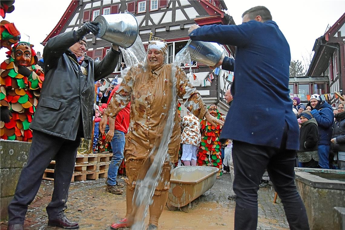 ...vor dem Rathaus in Unterweissach die kalte Frischwasserdusche, bei der Daniel Bogner (rechts) tatkräftig mithalf und auch seinen Spaß hatte. Fotos: Tobias Sellmaier 