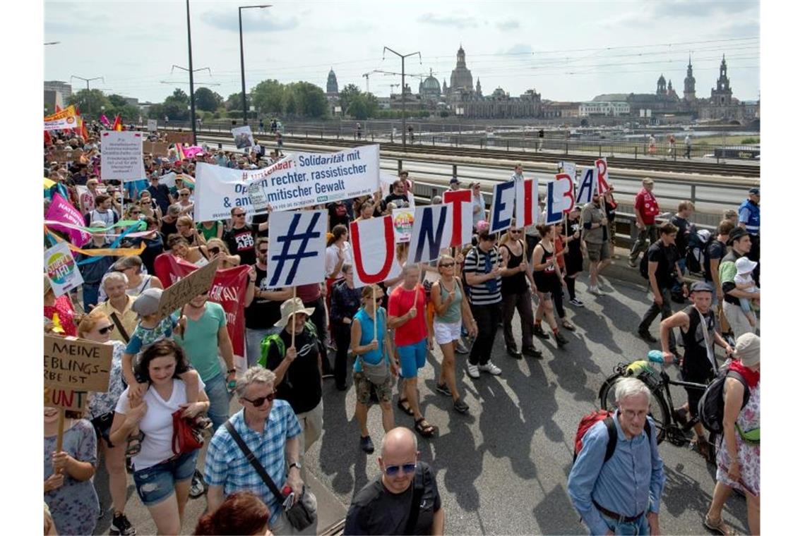 Vor der historischen Altstadtkulisse gehen Tausende Teilnehmer der Demonstration des Bündnisses #Unteilbar über die Carolabrücke in Dresden. Foto: Robert Michael