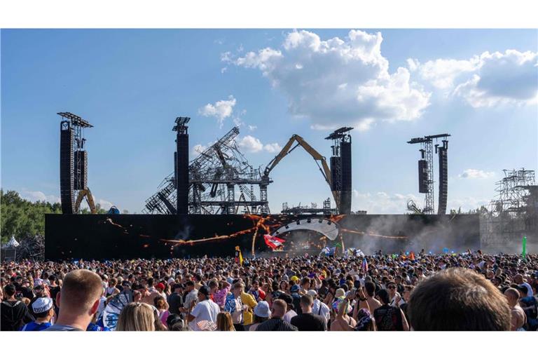 Vor der Kulisse der niedergebrannten Hauptbühne in Boom feiern die Festivalbesucher.